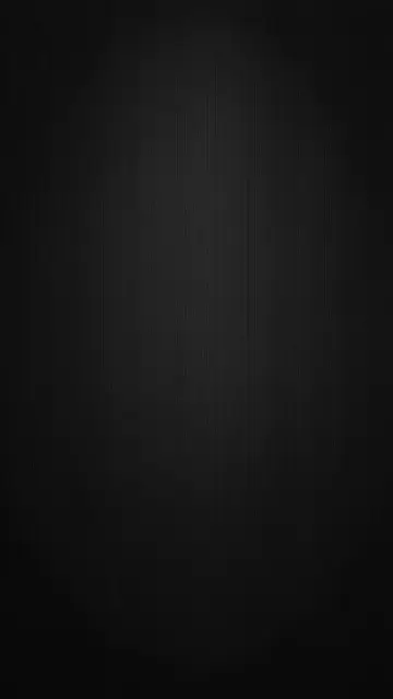 Vertical matte black fine textured surface with soft central light falloff