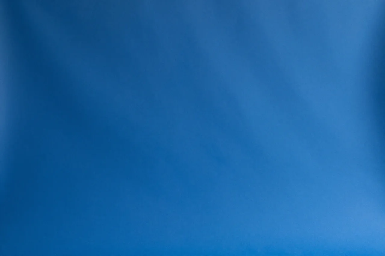 Full frame even matte cobalt blue paper studio background with soft subtle tonal variation
