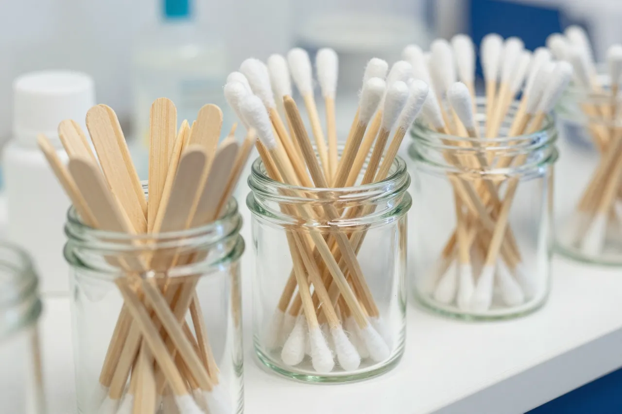 Glass jars holding wooden tongue depressors and cotton swabs sit on a white clinic counter
