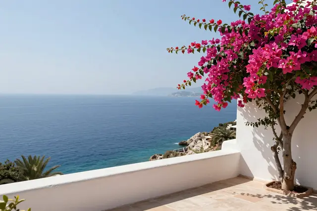 Whitewashed sunlit terrace with pink bougainvillea overlooking calm blue Mediterranean sea
