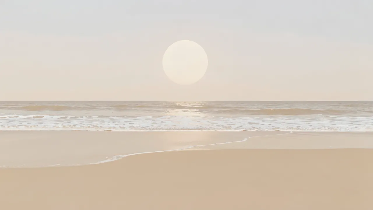 Pale soft sun hangs over a quiet beige beach with thin gentle surf along the shore