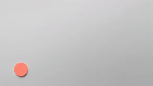 A soft pale gray gradient desktop wallpaper with a small solid coral circle resting low on the left side.
