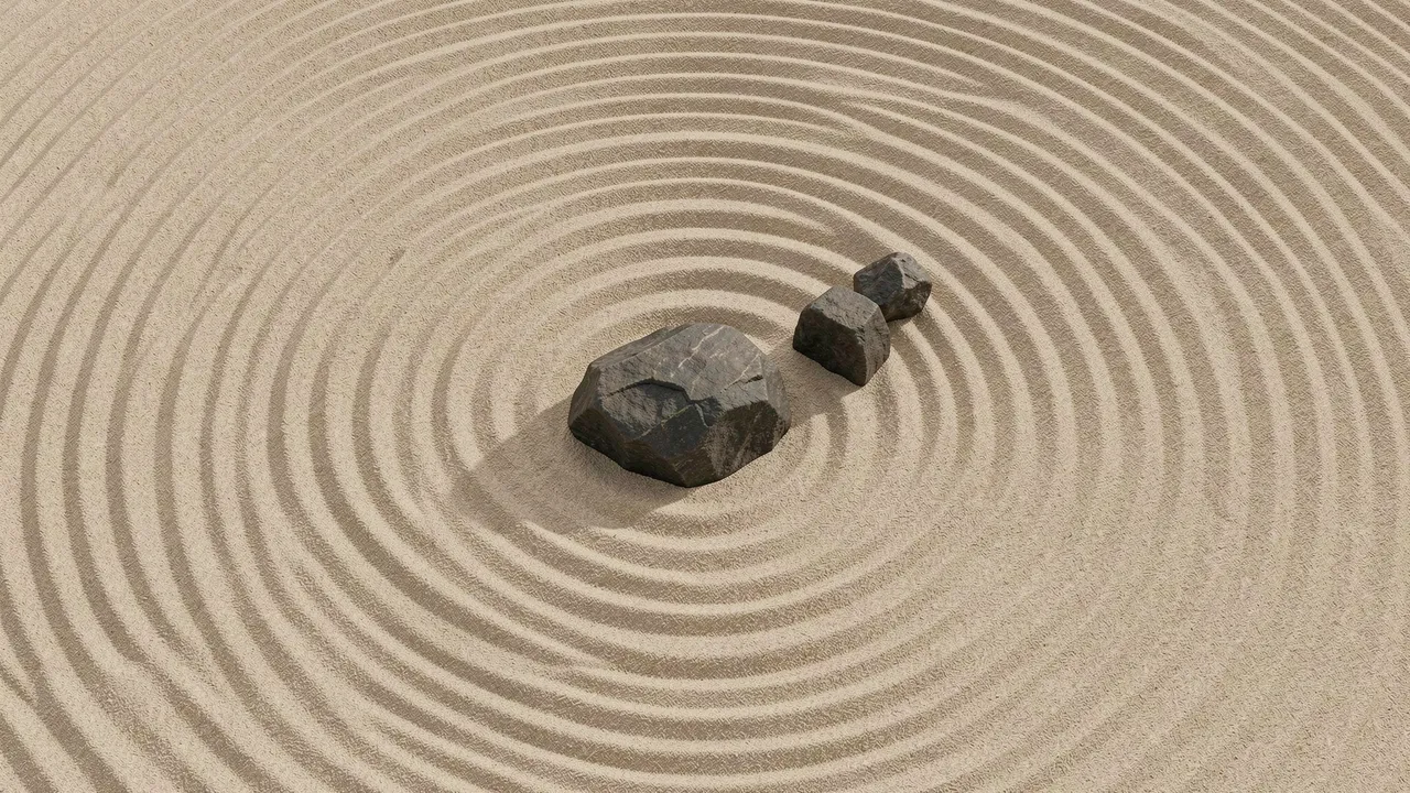 Top-down view of a raked minimalist zen garden with three dark stones set in beige sand