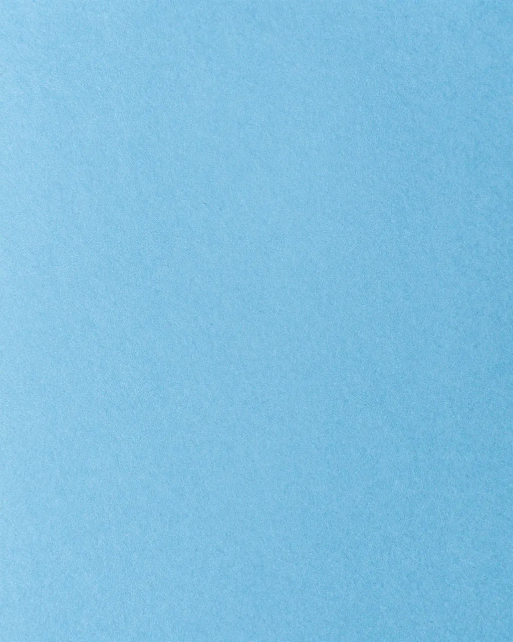 Full frame close-up of smooth light blue fibrous construction paper with even flat lighting
