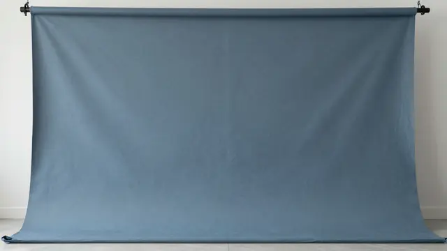 A draped hand-painted blue-gray canvas studio backdrop hangs from a top roller stand