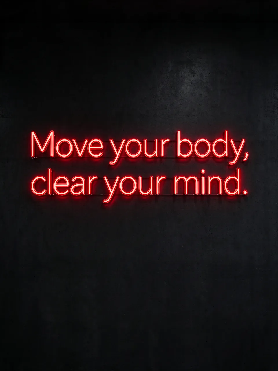 Glowing red neon sign reading "Move your body, clear your mind." mounted on a dark textured wall