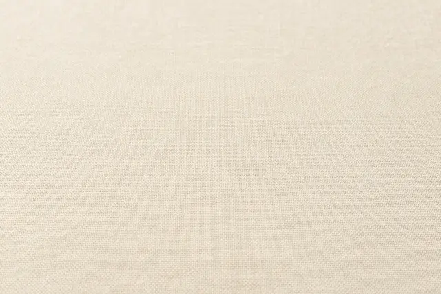 Close up of soft woven natural beige linen fabric surface showing fine weave details