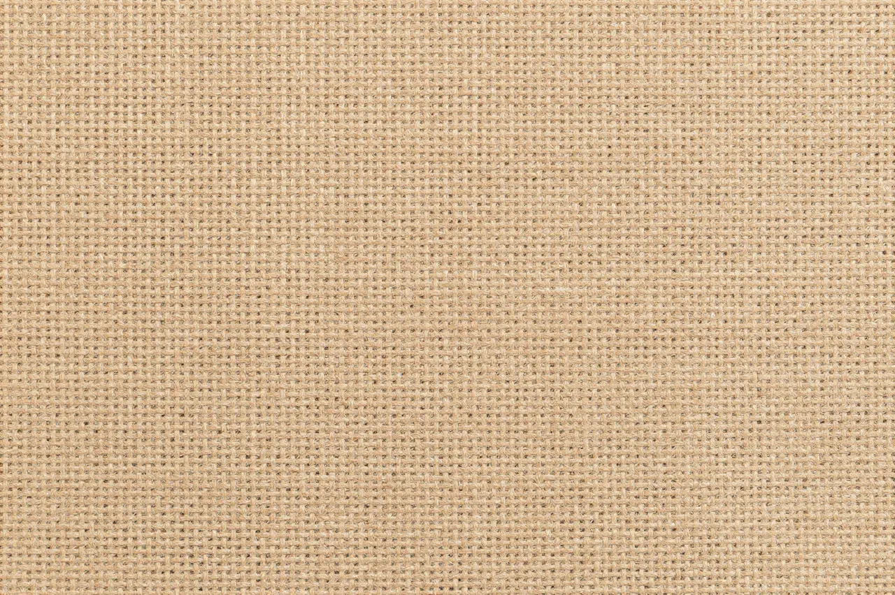 A full frame close-up view of uniform natural tan burlap woven texture