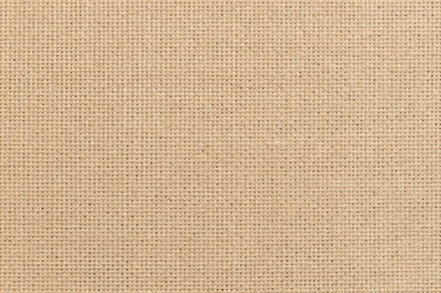 A full frame close-up view of uniform natural tan burlap woven texture