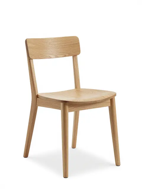 A minimalist bentwood natural oak dining chair stands isolated on a pure white studio background.