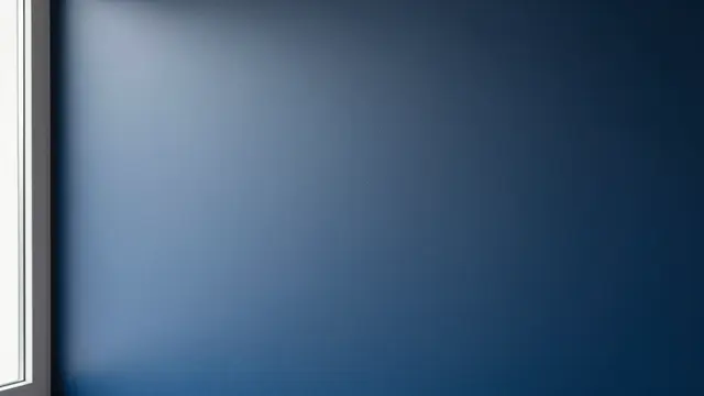 Soft diffused window light falls across a matte navy blue interior wall from a left side window frame