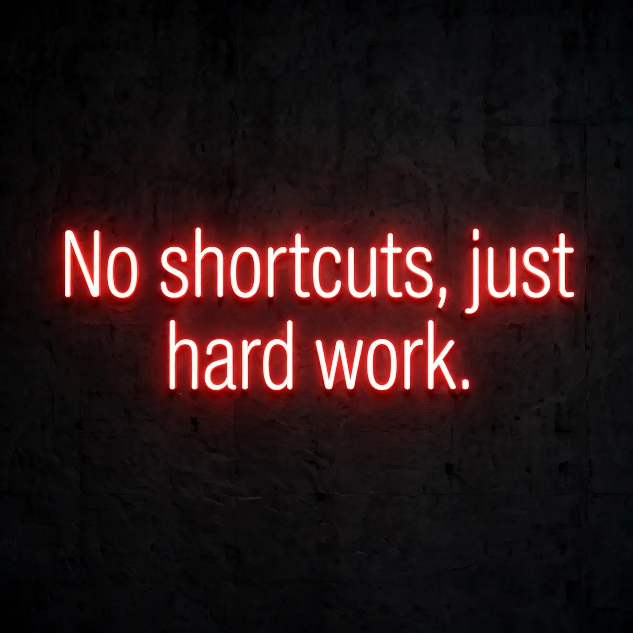 Glowing red neon sign reading "No shortcuts, just hard work." mounted on a dark textured wall