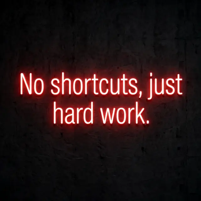 Glowing red neon sign reading "No shortcuts, just hard work." mounted on a dark textured wall