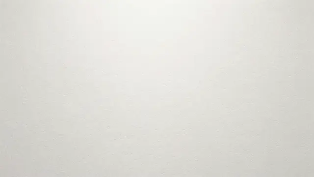 Smooth off-white paper surface with fine grain texture and soft top lighting
