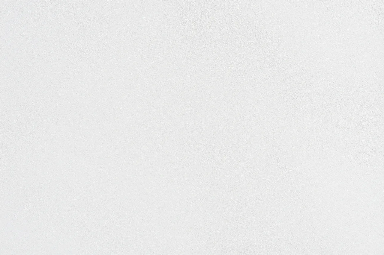 Full frame close-up of a fine bumpy off-white sprayed wall finish with subtle even texture
