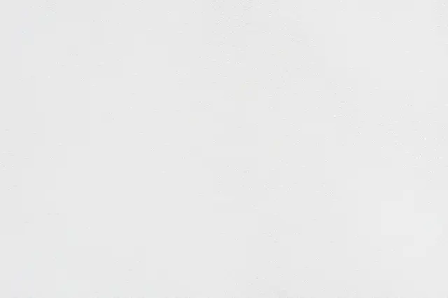 Full frame close-up of a fine bumpy off-white sprayed wall finish with subtle even texture