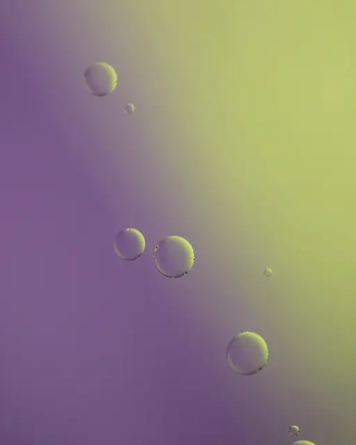 Floating translucent oil bubbles drift across a smooth gradient violet and lime backdrop