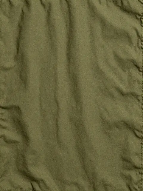 Full frame close-up of wrinkled olive green waxed canvas with soft natural creases