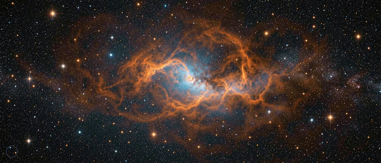 A sprawling ultrawide nebula with orange filaments and blue core set against a dense field of glowing stars