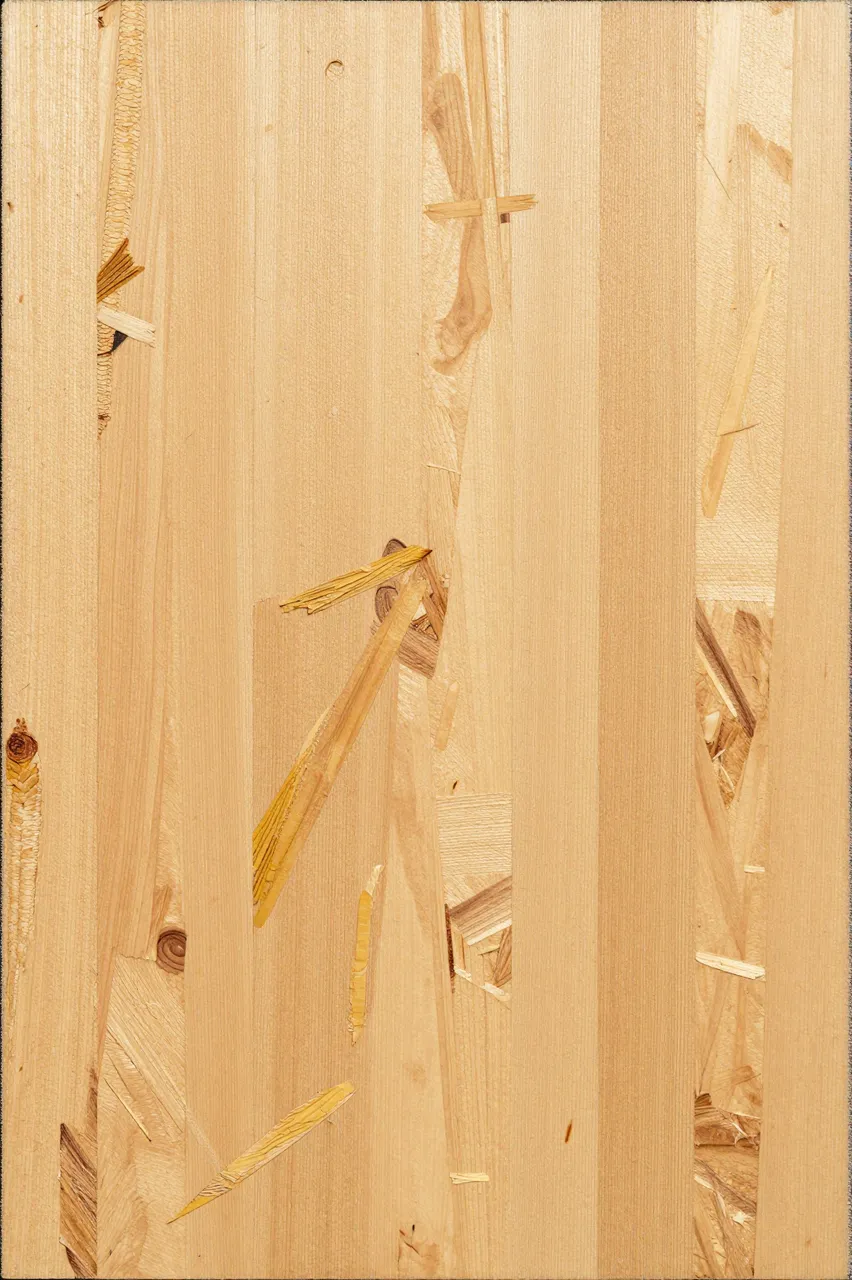 Full frame close-up of light oriented strand board showing pressed golden wood flakes under even flat lighting
