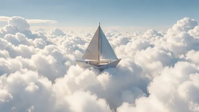 A white origami sailboat floats gently atop a vast sea of fluffy cumulus clouds under a pale blue sky.