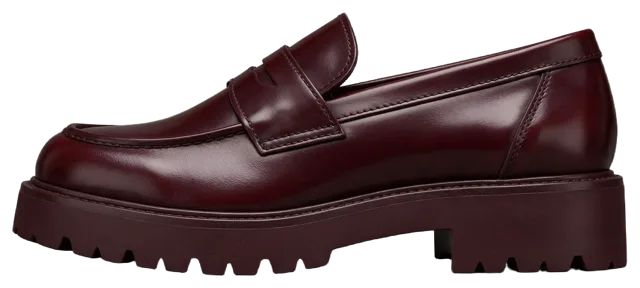 Side profile view of a single glossy oxblood leather chunky-soled penny loafer