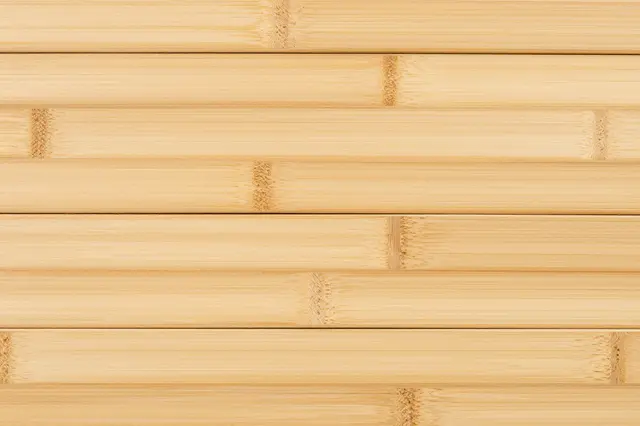 Full frame close up of horizontal pale bamboo planks showing distinct natural nodes and grain