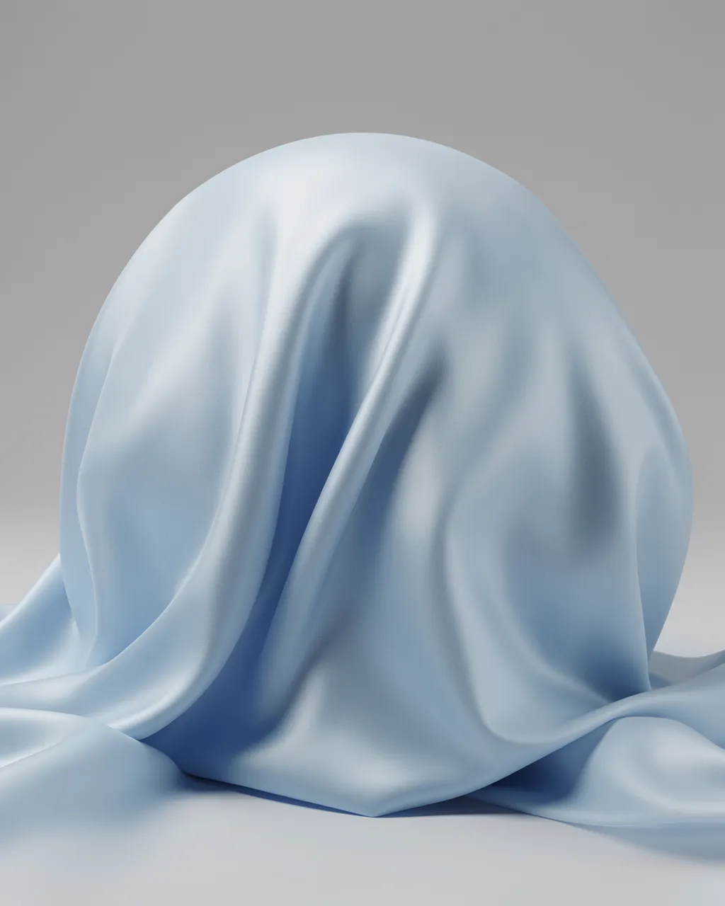 Pale blue satin fabric draped over a rounded hidden shape against a neutral gray studio background