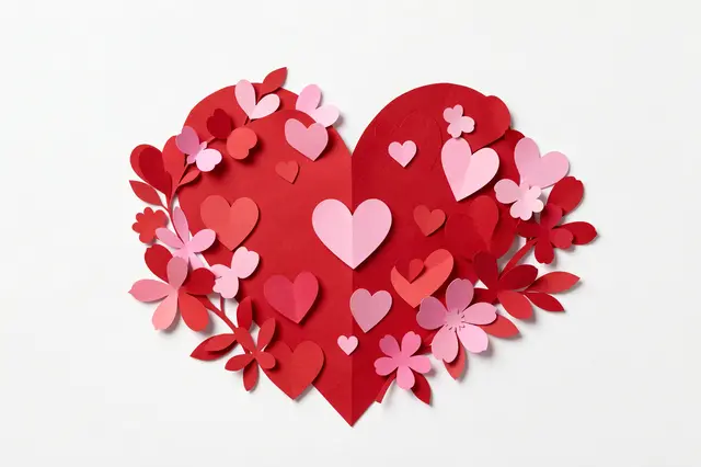 Layered paper cut illustration of a large red heart decorated with smaller hearts and pink flowers on a white background