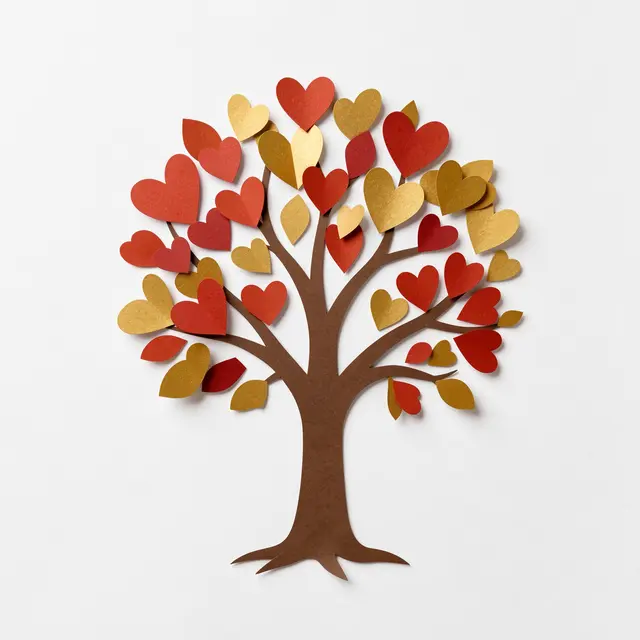 Paper cut illustration of a small tree with red and gold heart shaped leaves on a plain white background