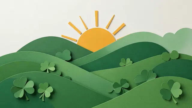 Layered paper cut illustration of green rolling hills dotted with shamrocks and a rising yellow sun