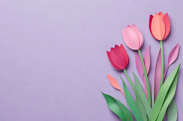 Layered paper tulip flowers arranged on the right side of a solid lilac background with empty copy space on the left