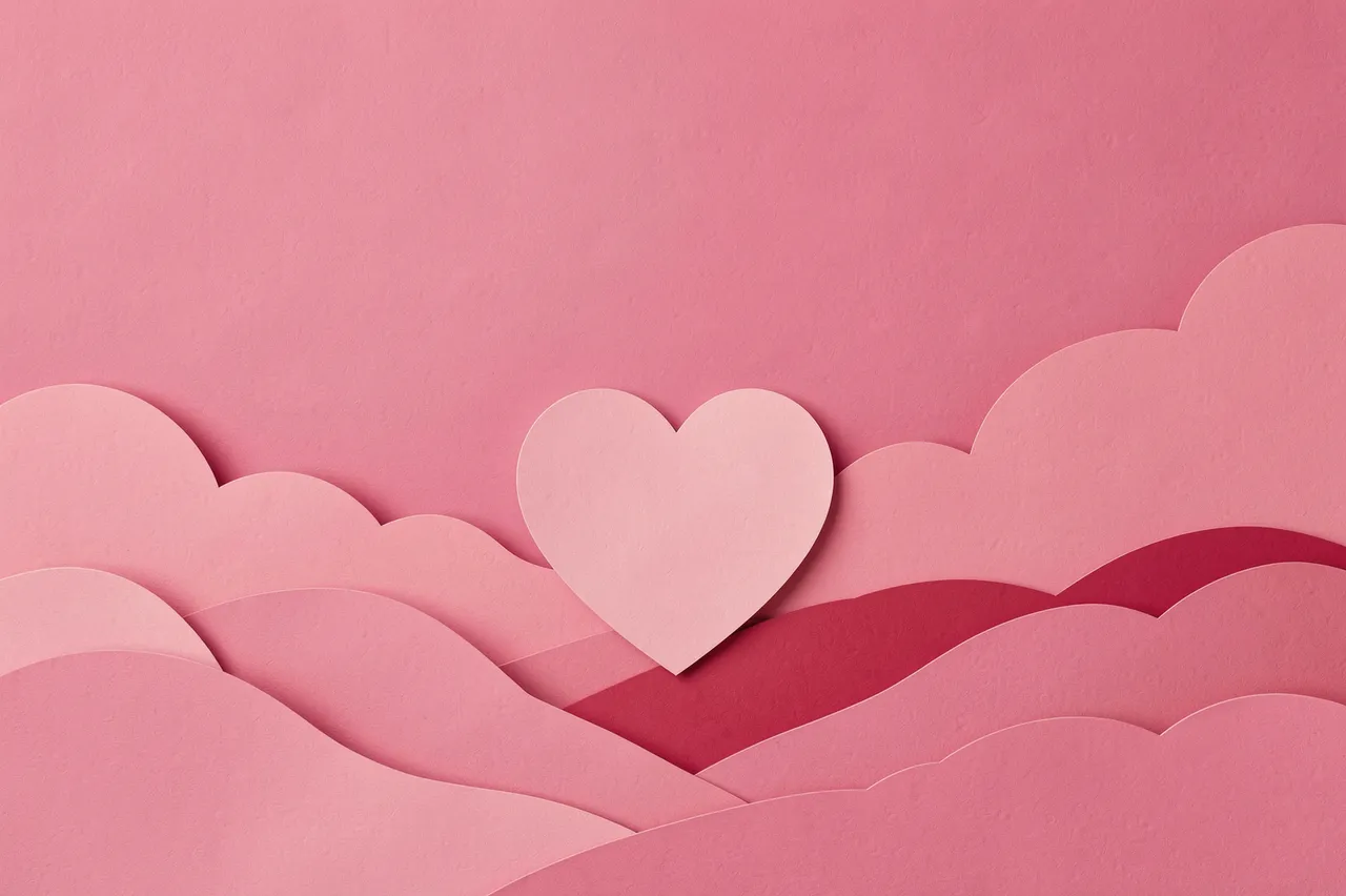 Layered paper craft scene with a pink heart and copy space over soft paper hills and a pink sky background
