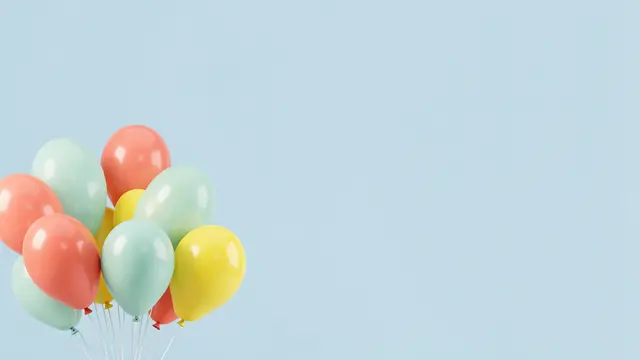 Bunch of glossy coral, mint and lemon balloons sits in the lower left against a pale blue empty background