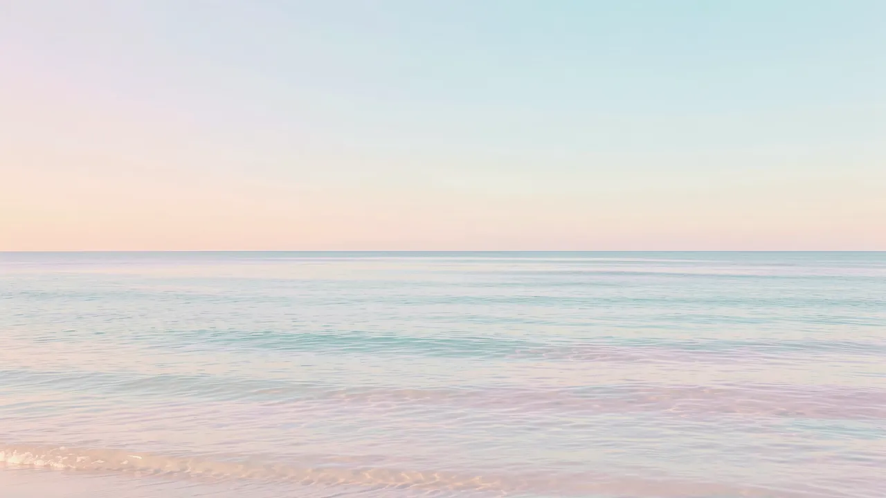 Calm pastel gradient sky meets gentle pale ocean waves along a quiet horizon
