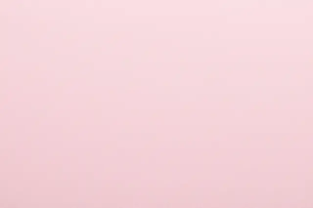 Full frame close-up of smooth soft blush pink paper with a faint fine felted surface nap.
