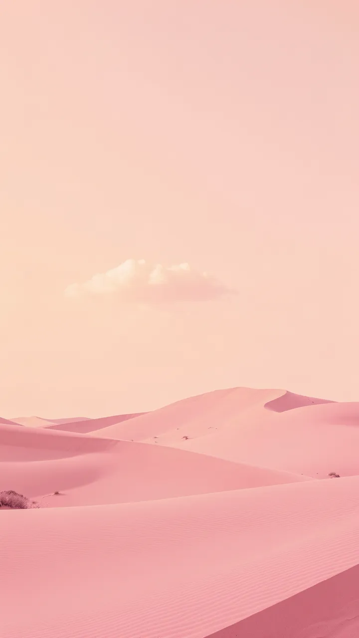 Soft rippled pink sand dunes stretch below a pale peach sky holding one small fluffy cloud
