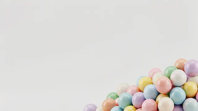 Glossy pastel 3D spheres clustered in the bottom right corner with empty light gray space on the left