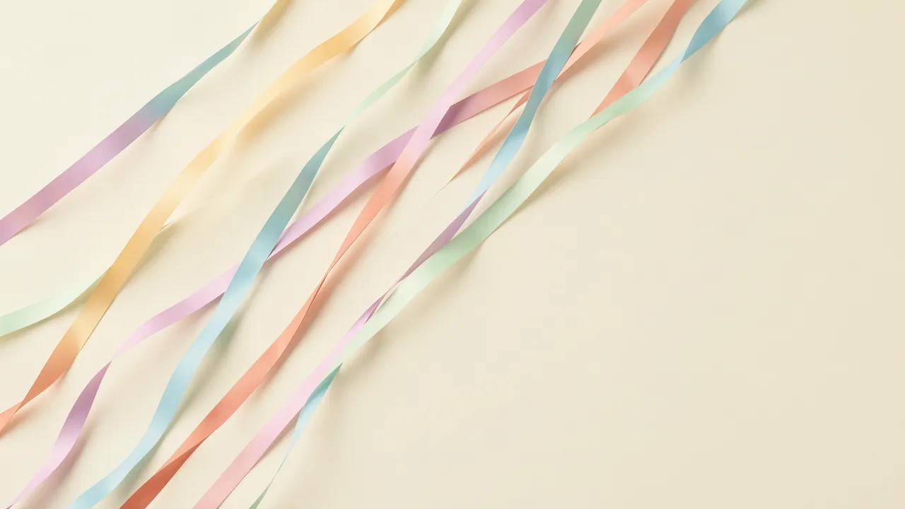 Twirling diagonal pastel paper streamers lie across a cream backdrop with empty copy space on the right