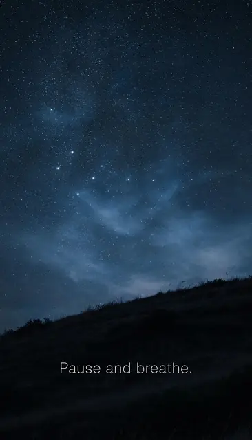 Starry night sky over a dark grassy hill with the text "Pause and breathe." centered near the bottom.