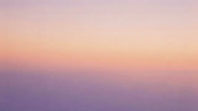 A smooth grainy horizontal gradient blending soft peach and lavender tones