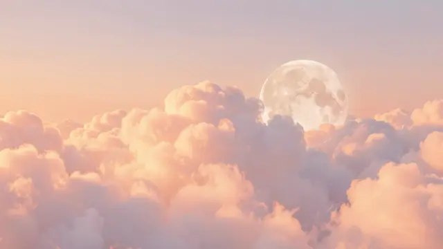 A large pale full moon sits beside soft peach-glowing cotton clouds at pastel sunrise