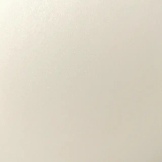 Full frame close-up of smooth pearlescent ivory paper with a soft subtle shimmer