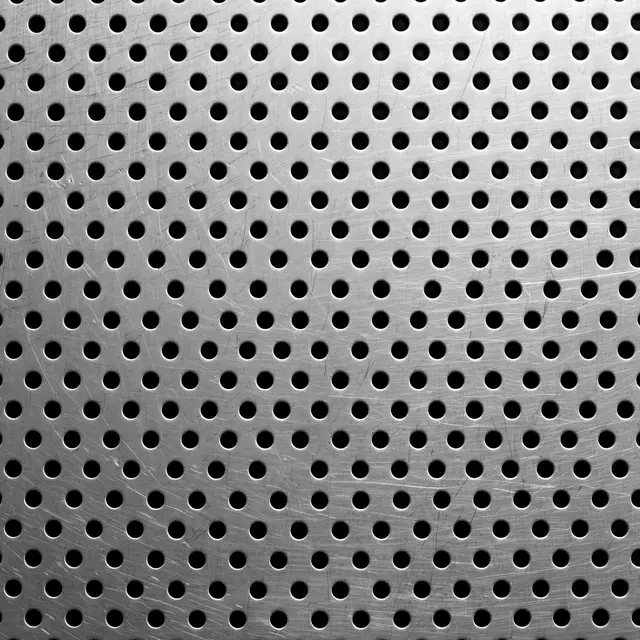 Full frame close-up of brushed perforated stainless steel with uniform round holes over a dark background
