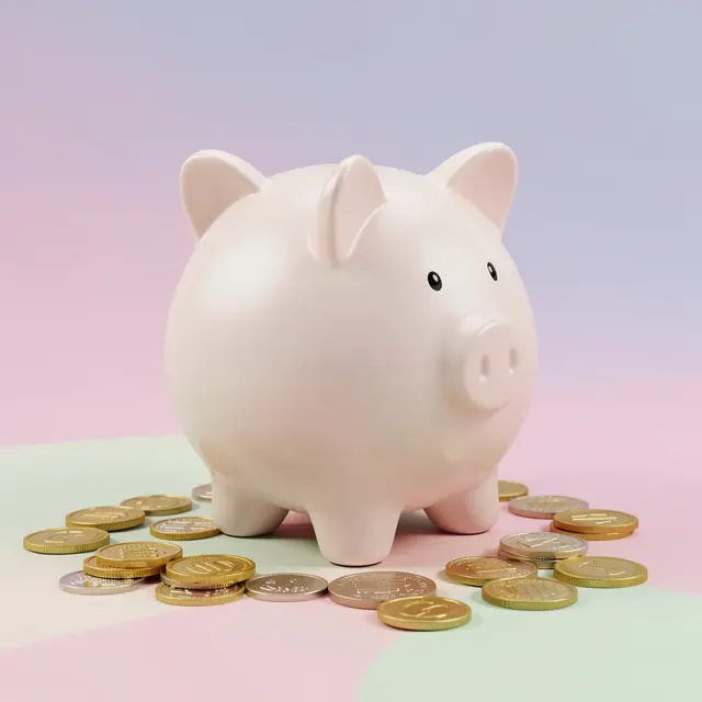 A pale pink piggy bank sits surrounded by gold and silver coins on a soft pastel gradient background
