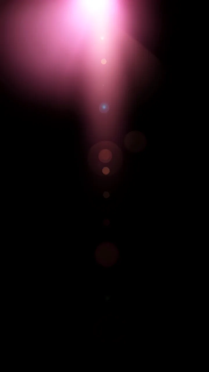 A vertical soft pink lens flare with trailing bokeh orbs against a solid pure black background