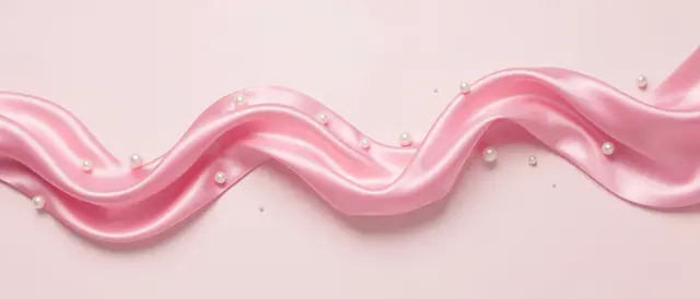 A rippling soft wave of pink satin ribbon scattered with pearls rests on a pale pink background.