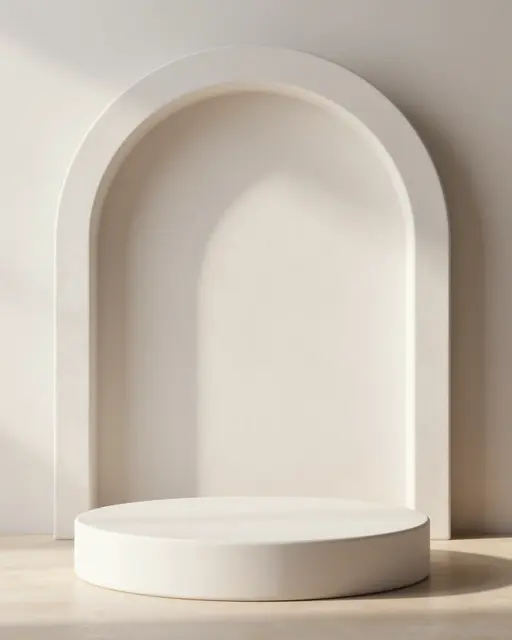 Round white plaster display podium sits in front of a curved plaster arch in soft warm daylight