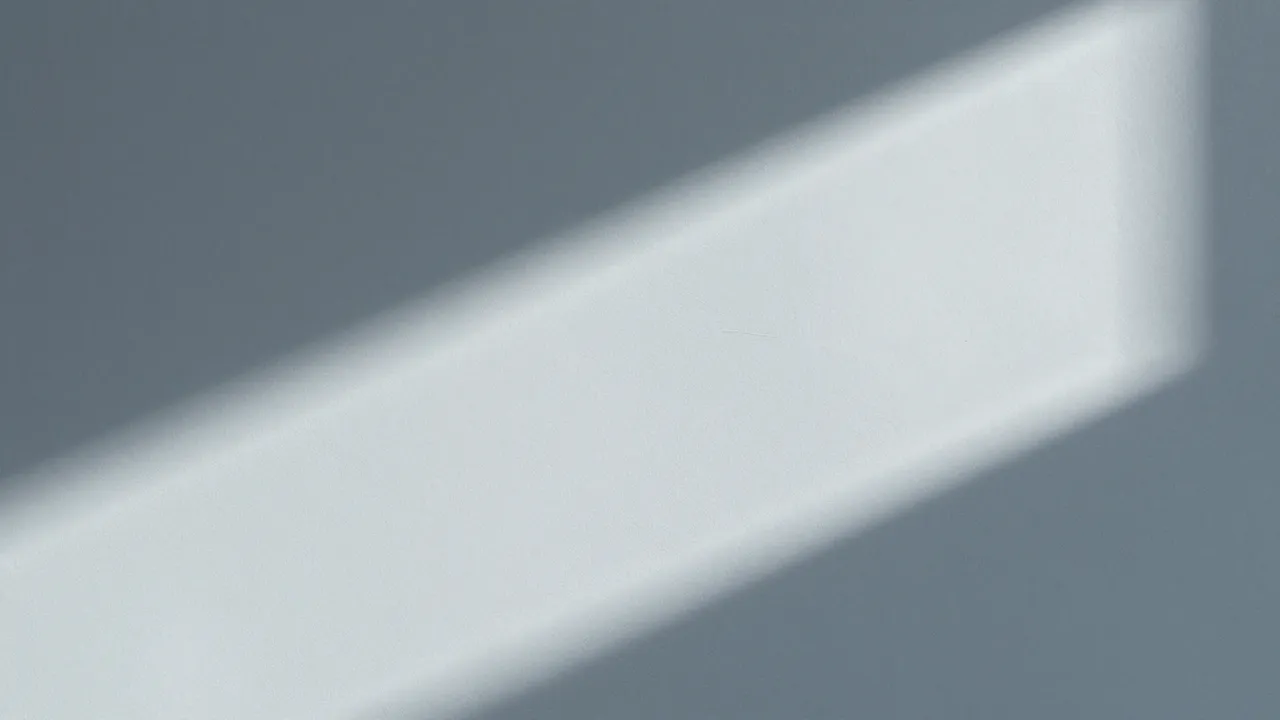 Soft diagonal window light falls across a smooth blue grey plaster wall surface