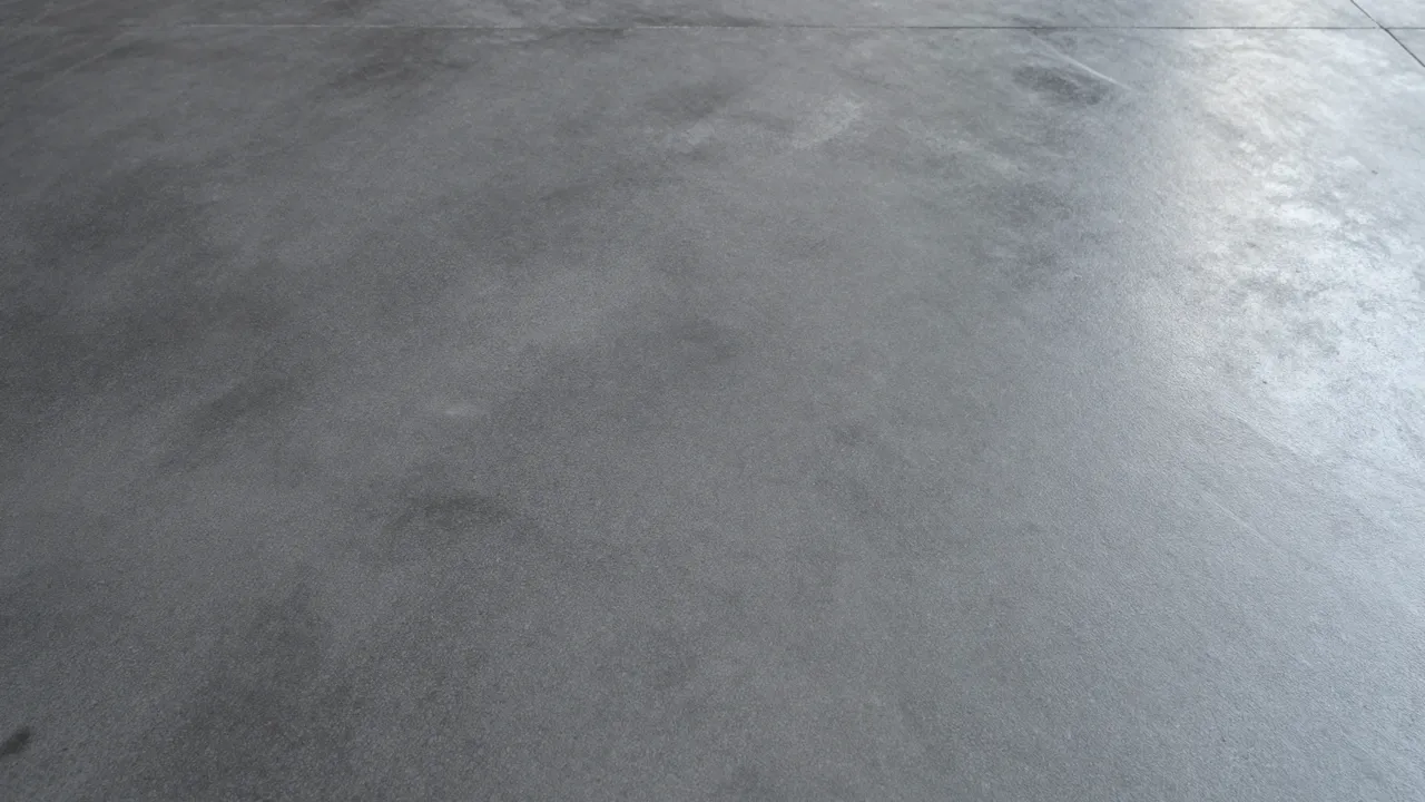 Top view of a smooth dark gray polished concrete floor filling the full frame with subtle reflective sheen
